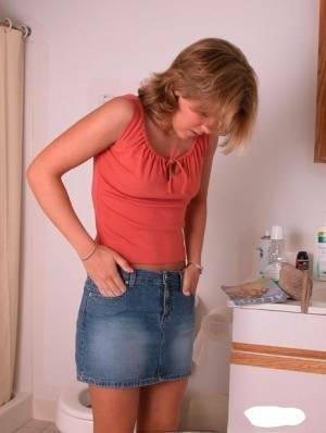 Amateur girl Karen hikes her denim skirt in the bathroom to expose her panties on galpictures.com