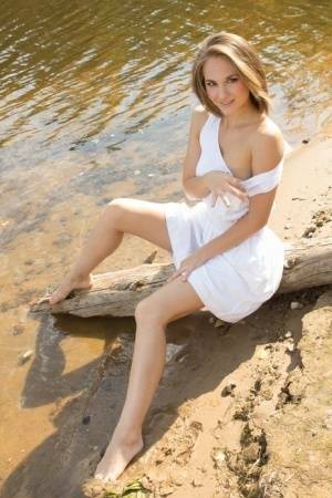 White teen of legal age shows off her naked body on a log that's beached on galpictures.com