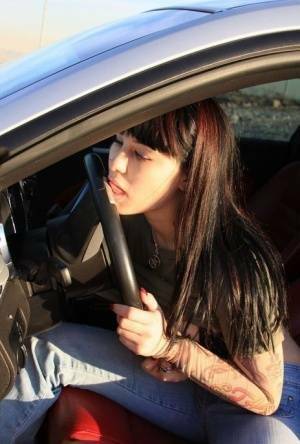 Amateur girl Susy Rocks flips the bird while exposing her big tits in a car on galpictures.com