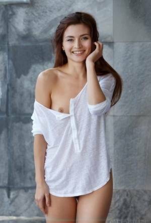 Petite teen divests herself of a white shirt to pose nude in and out of a pool on galpictures.com