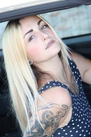 Tattooed girl Medusa Blonde shows her bare feet and ass while in a car on galpictures.com