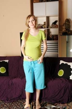 Smiley pregnant amateur with puffy nipples and hairy gash getting naked on galpictures.com