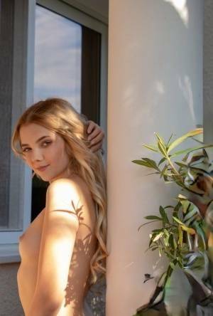 Young blonde Chanel Fenn shows her sexy ass while getting naked in a garden on galpictures.com