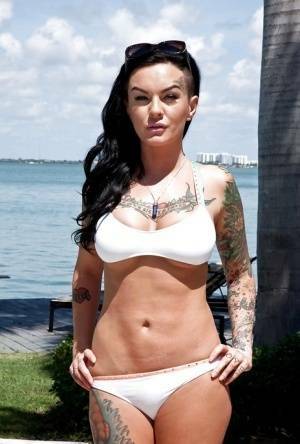 Tattooed whore Lolo Luscious exposing big hooters in swimming pool on galpictures.com