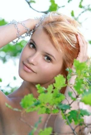 Adorable redhead Violla A displays her naked teen body atop a rock outdoors on galpictures.com