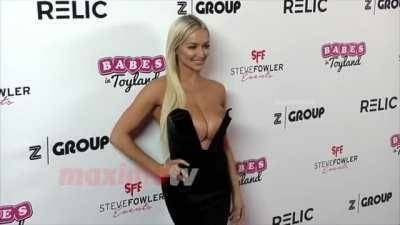Lindsey Pelas' tits are so big that she have to push them back on galpictures.com