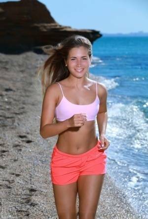 Fit young girl Mary Rock gets completely naked on a beach after exercising on galpictures.com