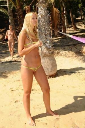 Natural blonde takes off her bikini to get totally naked on a beach on galpictures.com